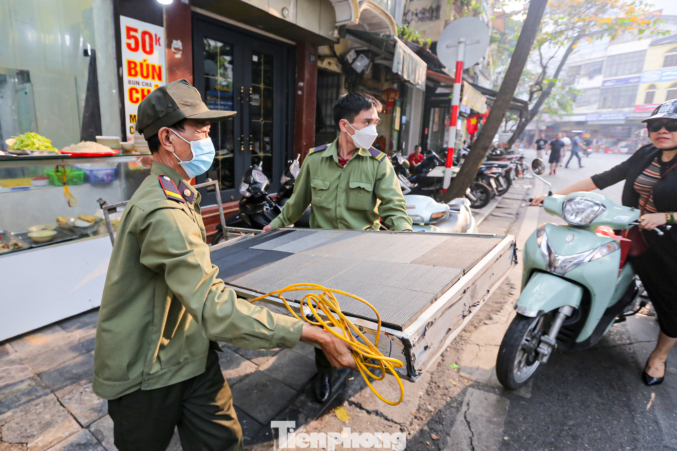 Lực lượng chức năng phường Hàng Gai (quận Hoàn Kiếm, Hà Nội) thu giữ biển quảng cáo đặt trái phép trên vỉa hè phố Hàng Quạt.