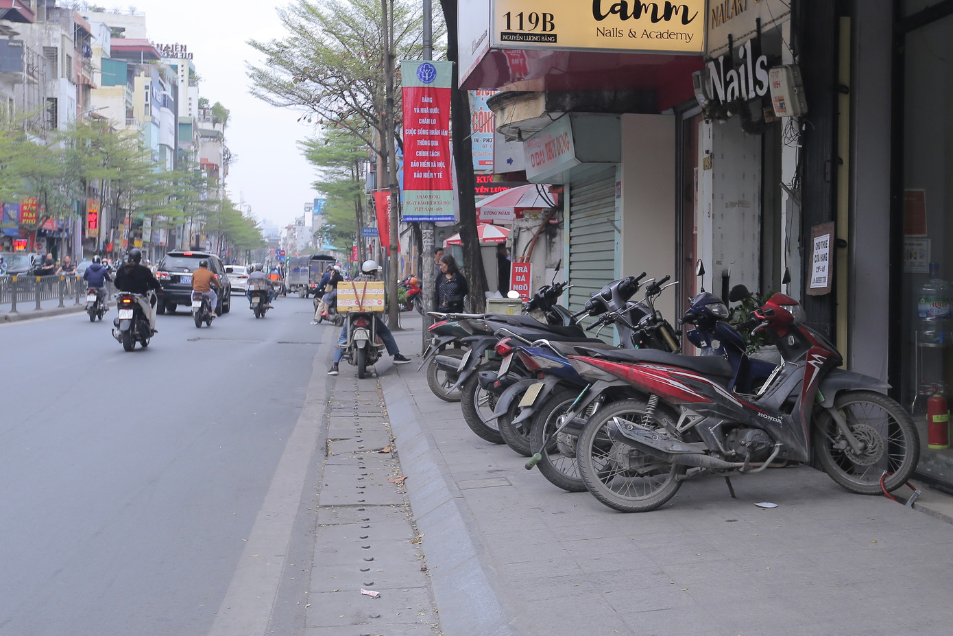 Ghi nhận của PV, vỉa hè vẫn đang bị chiếm dụng để bày hàng hóa, biển quảng cáo, bàn ghế kinh doanh ăn uống, đỗ xe... đẩy người đi bộ xuống lòng đường