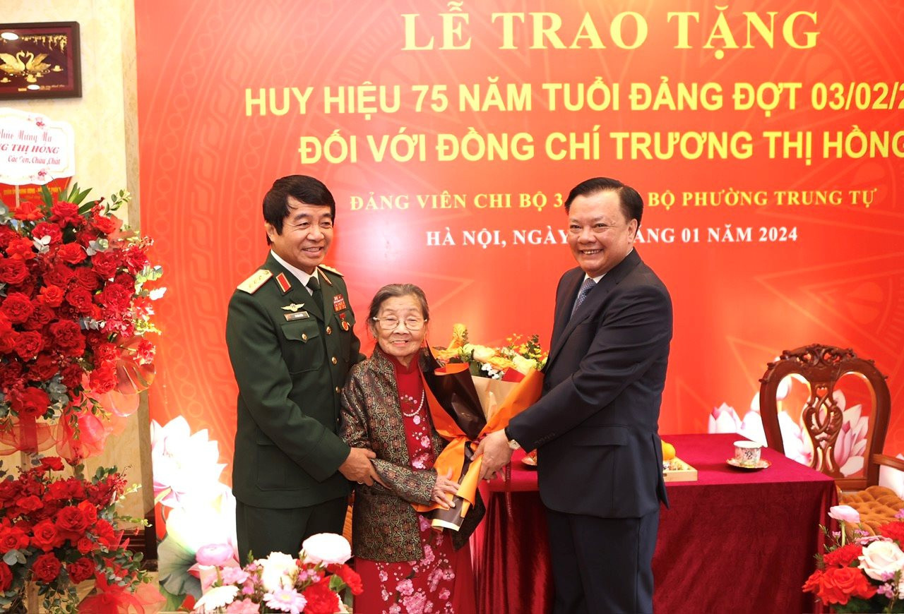Bí thư Thành ủy Hà Nội Đinh Tiến Dũng trao Huy hiệu 75 năm tuổi Đảng và tặng hoa chúc mừng đồng chí Trương Thị Hồng