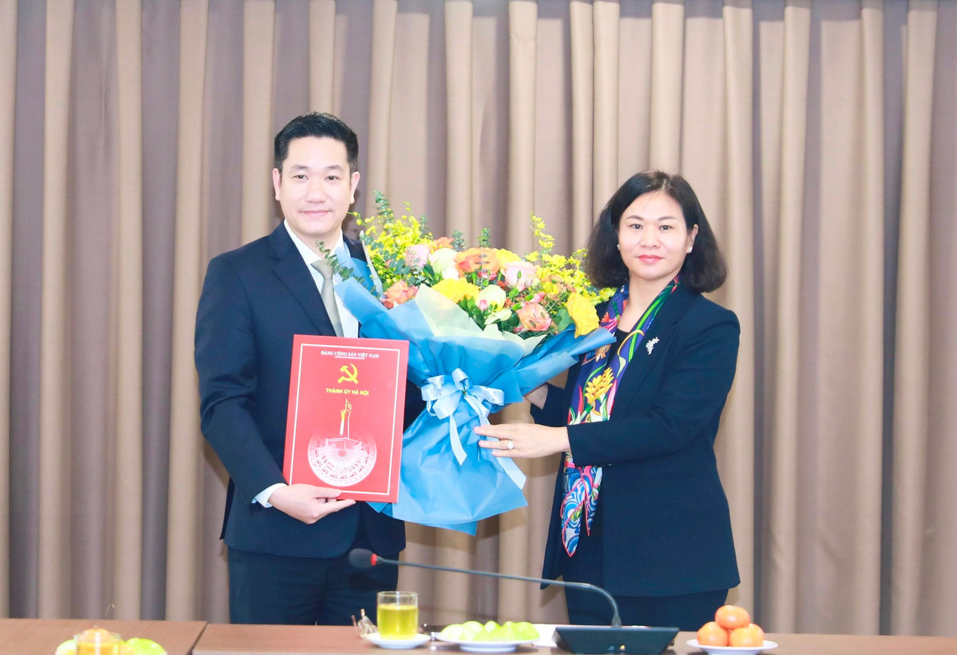 Phó Bí thư Thường trực Thành ủy Nguyễn Thị Tuyến trao quyết định điều động, tặng hoa chúc mừng ông Nguyễn Huy Cường