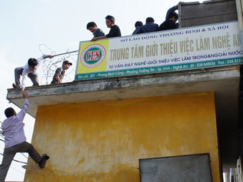 Lao động bất chấp nguy hiểm leo trèo để được đăng ký dự thi tiếng Hàn tại TP Vinh, Nghệ An. Ảnh: A.Khánh