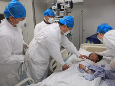 Các bác sĩ Bệnh viện Ditan đang điều trị bé gái 7 tuổi nhiễm H7N9 ở Bắc Kinh. Ảnh: Xinhua