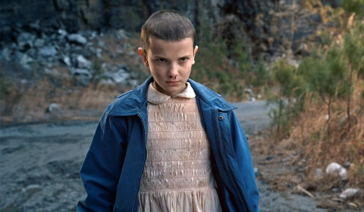 Dù phải cạo đầu vì vai diễn nhưng Millie vẫn hết sức vui vẻ. - Nguồn: Netflix.