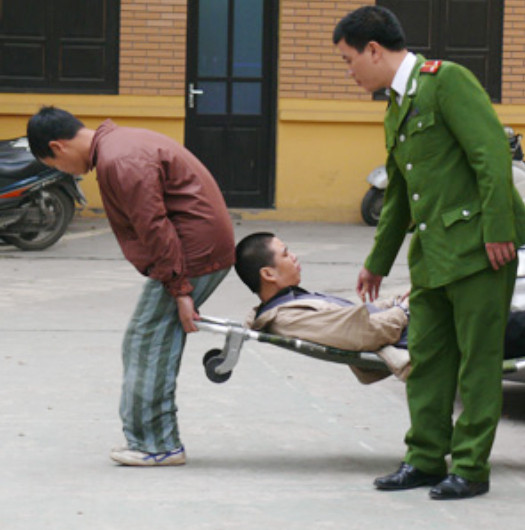 Do bị liệt, Tuấn được đưa ra tòa bằng cáng