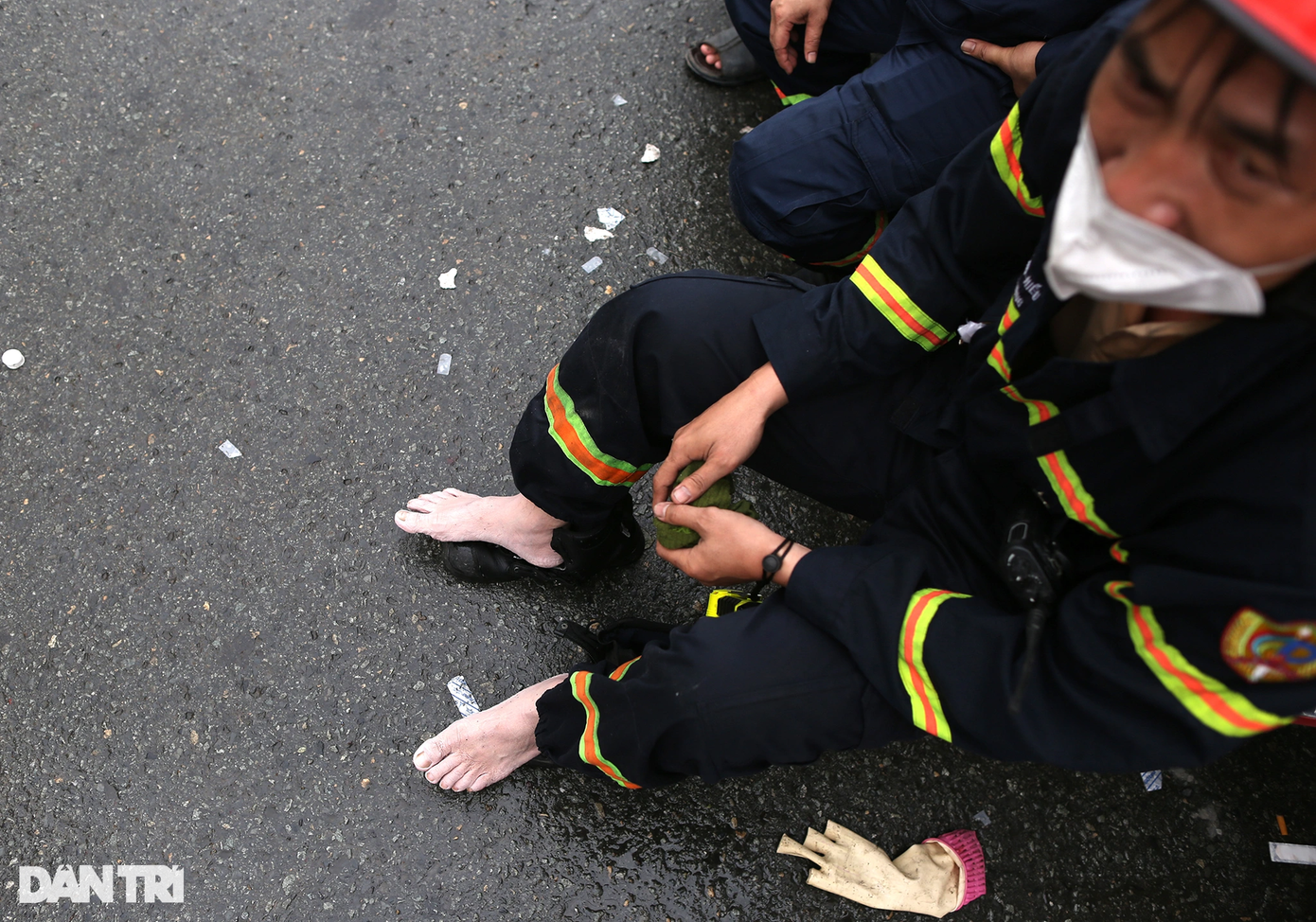 Một chiến sĩ PCCC ngồi nghỉ sau gần 10 giờ đồng hồ tham gia chữa cháy. "Tôi cùng các đồng đội bắt đầu tác chiến từ 21h đêm qua, tới tận bây giờ mới tạm nghỉ để thay ca", chiến sĩ này cho hay.