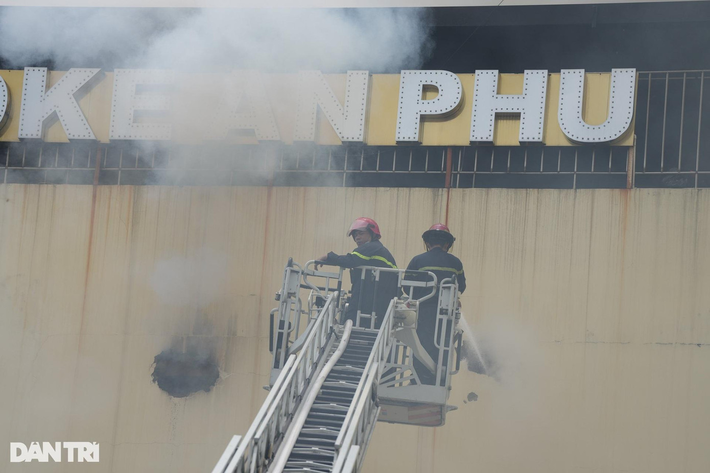 Lính cứu hỏa đục tường để thoát khói và phun nước vào bên trong.