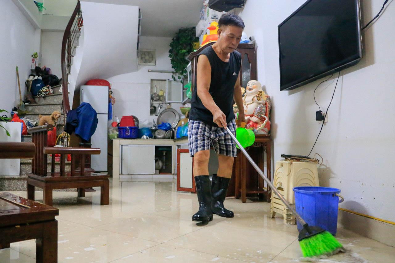 Gia đình ông Long là một trong những hộ chủ động xây nền cao trong ngõ để tránh ngập. Nhưng sau trận mưa đêm qua, nước vẫn dềnh vào nhà, sáng nay ông tranh thủ dậy sớm dọn dẹp. “Mưa lớn nhiều khi 'chạy lũ' không kịp vì nhà quá nhiều đồ linh tinh”, ông Long vừa nói vừa lắc đầu. Gia đình ông Long là một trong những hộ chủ động xây nền cao trong ngõ để tránh ngập. Nhưng sau trận mưa đêm qua, nước vẫn dềnh vào nhà, sáng nay ông tranh thủ dậy sớm dọn dẹp. “Mưa lớn nhiều khi 'chạy lũ' không kịp vì nhà quá nhiều đồ linh tinh”, ông Long vừa nói vừa lắc đầu.