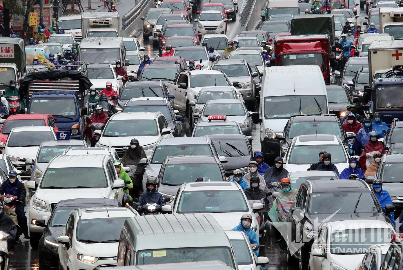 Vào giờ cao điểm, đường Trường Chinh hướng đi đường Láng khá đông đúc, xe máy "điền vào chỗ trống" giữa những hàng dài ô tô trong trời mưa lạnh.