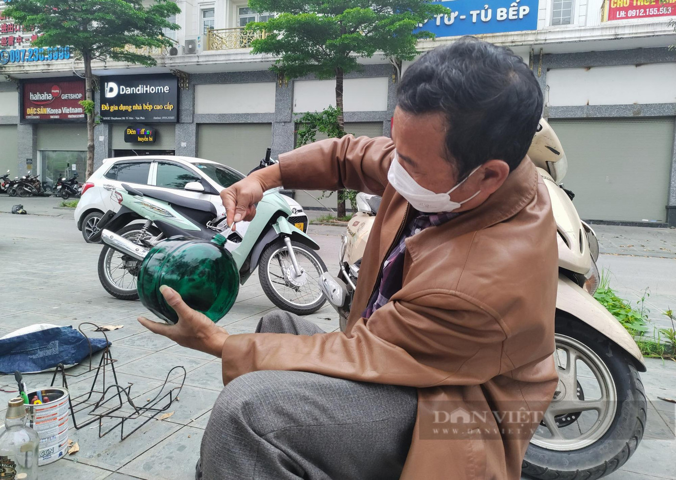 Ông Khoa đang làm vệ sinh vỏ một chai rượu tây để bán cho khách. Ông Khoa đang làm vệ sinh vỏ một chai rượu tây để bán cho khách.