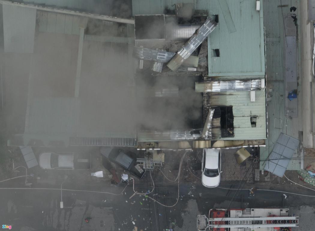 Sau 12 tiếng kể từ khi vụ cháy xảy ra, khói vẫn âm ỉ bốc cao hàng chục mét ở tầng trên của quán karaoke An Phú. Ảnh: Zing