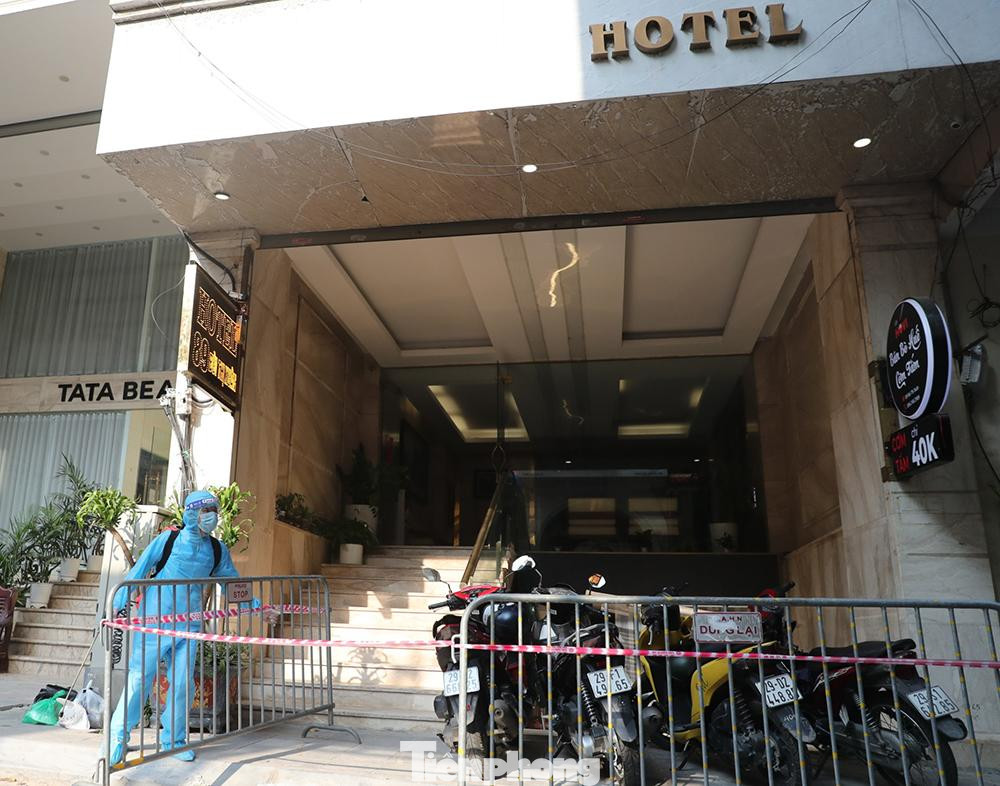 Lực lượng chức năng tiến hành lập hàng rào phong tỏa, phun khử khuẩn các khu vực trong và ngoài khách sạn. Ảnh: Như Ý