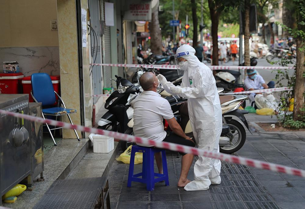 Lấy mẫu xét nghiệm cho chủ quán và nhân viên một hàng phở trên phố Tô Hiến Thành là nơi các ca dương tính từng tới ăn trong những ngày gần nhất.
