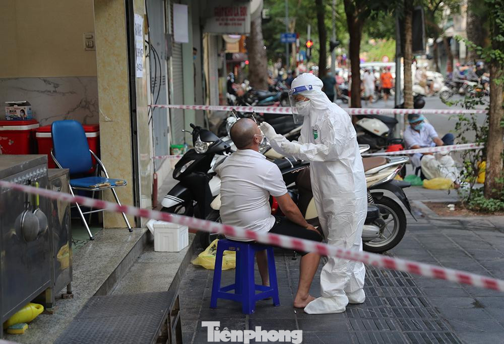 Nhân viên y tế thực hiện việc lấy mẫu xét nghiệm COVID-19 cho chủ quán, nhân viên