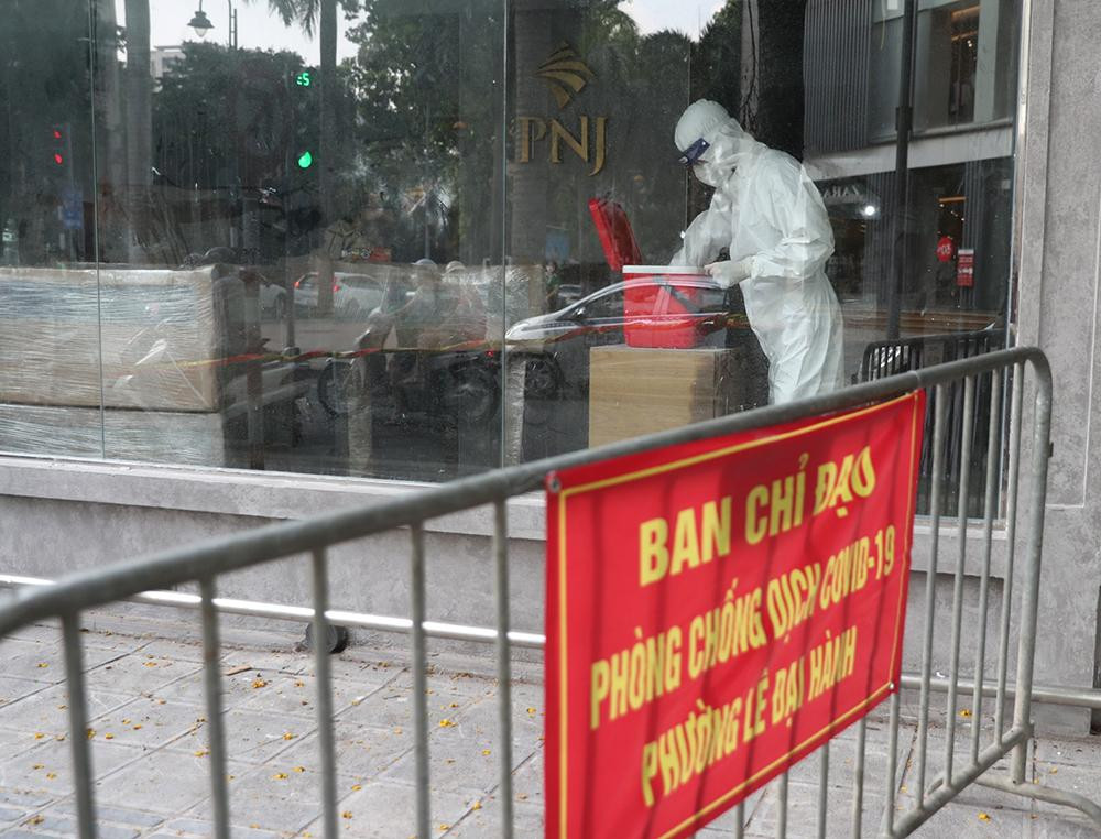Lực lượng chức năng lập rào chắn phong tỏa cửa hàng trên phố Bà Triệu, nơi F0 từng đến, để lấy mẫu xét nghiệm nhân viên tại đây.