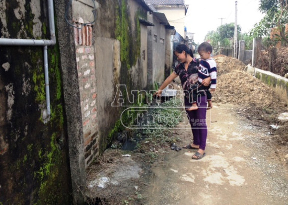 Chị Hằng chỉ vào dòng nước xả thải luôn gây ô nhiễm của nhà cô Nga. Chị Hằng chỉ vào dòng nước xả thải luôn gây ô nhiễm của nhà cô Nga