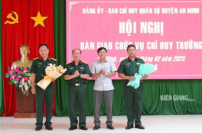 Đại tá Nguyễn Văn Ngành tặng hoa chúc mừng hai đồng chí được điều động, bổ nhiệm. Ảnh: Báo Kiên Giang.