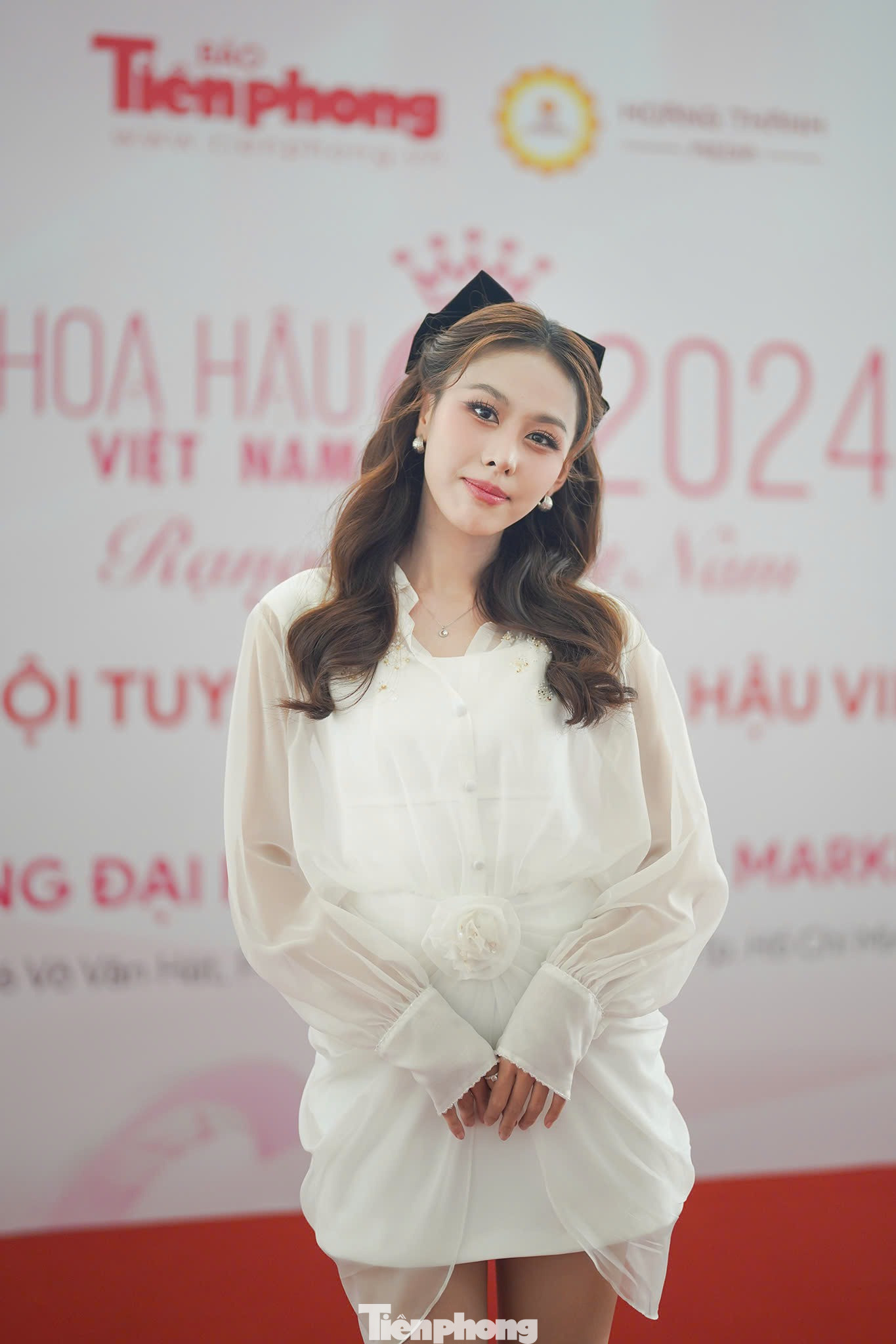 So với phong cách trưởng thành tại Đại học Ngân hàng TPHCM một ngày trước đó, chiếc váy trắng &quot;bánh bèo&quot; cùng kiểu tóc buộc nửa đầu, cài thêm nơ phía sau, giúp Ngọc Hằng biến hóa sang hình ảnh ngọt ngào, nữ tính.