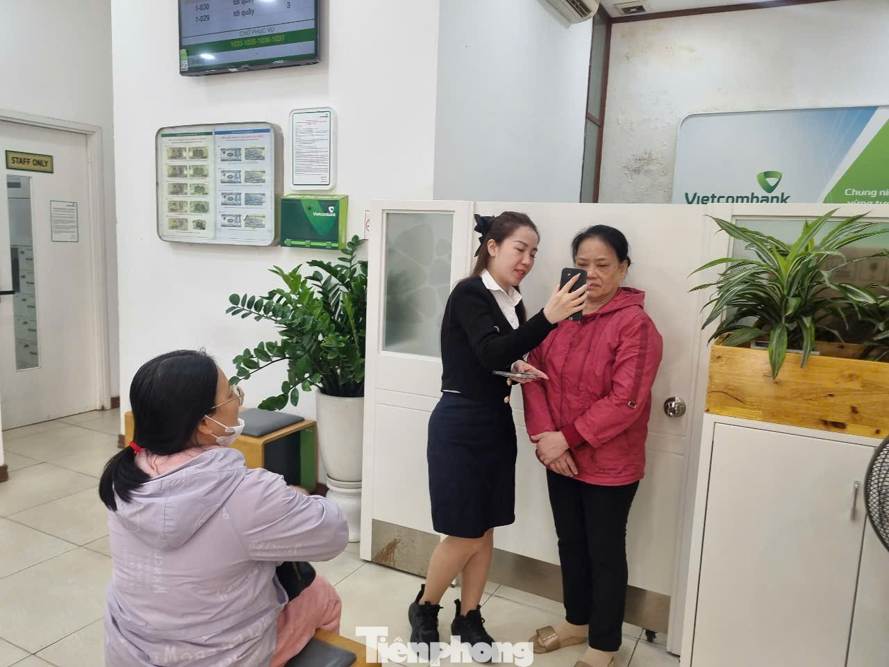 Nhân viên ngân hàng Vietcombank cài đặt cho khách hàng sinh trắc học (ảnh: N.M).