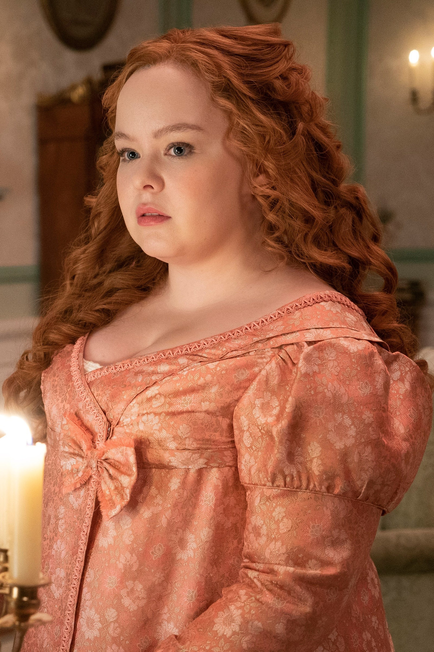 Trong phim, Penelope được mô tả là cô gái có ngoại hình mũm mĩm, không phù hợp với thị hiếu nhan sắc của thời đại. Cùng với cách ăn mặc màu mè, trẻ con, Penelope được xem là không thu hút trong mắt các thanh niên quý tộc chưa vợ. Trong gia đình, cô không được mẹ xem trọng, thường xuyên bị hai chị gái bắt nạt, từ đó hình thành tính cách rụt rè, tự ti. Tuy nhiên, ẩn sâu trong vẻ ngoài lệch chuẩn là cô gái thông minh và luôn khao khát chứng tỏ bản thân. Đó là lý do cô quyết định tạo cho mình vỏ bọc Quý bà Whistledown - cây bút sắc sảo chuyên phơi bày các bí mật trong giới quý tộc Anh. Đây là một trong những nhân vật quan trọng nhất trong phim, có vai trò kết nối tất cả mùa của Bridgerton. Ảnh: Netflix.