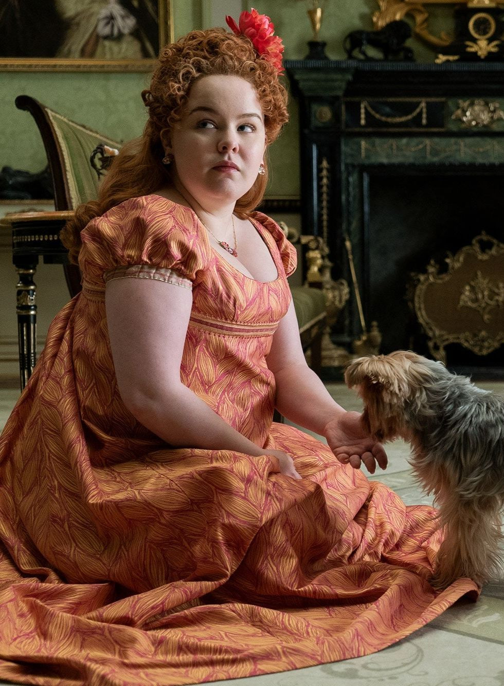 Trong phim, Penelope được mô tả là cô gái có ngoại hình mũm mĩm, không phù hợp với thị hiếu nhan sắc của thời đại. Cùng với cách ăn mặc màu mè, trẻ con, Penelope được xem là không thu hút trong mắt các thanh niên quý tộc chưa vợ. Trong gia đình, cô không được mẹ xem trọng, thường xuyên bị hai chị gái bắt nạt, từ đó hình thành tính cách rụt rè, tự ti. Tuy nhiên, ẩn sâu trong vẻ ngoài lệch chuẩn là cô gái thông minh và luôn khao khát chứng tỏ bản thân. Đó là lý do cô quyết định tạo cho mình vỏ bọc Quý bà Whistledown - cây bút sắc sảo chuyên phơi bày các bí mật trong giới quý tộc Anh. Đây là một trong những nhân vật quan trọng nhất trong phim, có vai trò kết nối tất cả mùa của Bridgerton. Ảnh: Netflix.