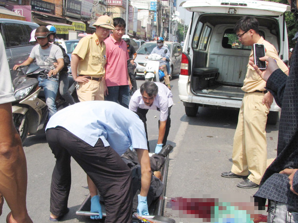 Lực lượng chức năng đưa xác nạn nhân lên xe. Ảnh: Lãng Phong