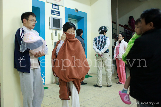 Đôi vợ chồng trẻ đang bế đứa con 10 ngày tuổi xuống tầng trệt của toà nhà chung cư CT3C ở khu đô thị Bắc Linh Đàm.