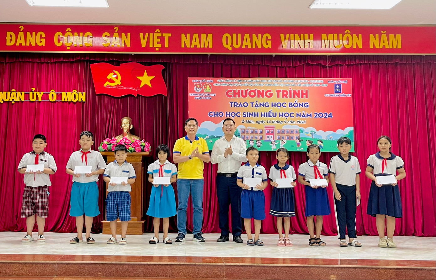 Anh Lâm Văn Tân và ông Nguyễn Ngọc Huy trao học bổng cho học sinh nghèo hiếu học trên địa bàn quận Ô Môn.