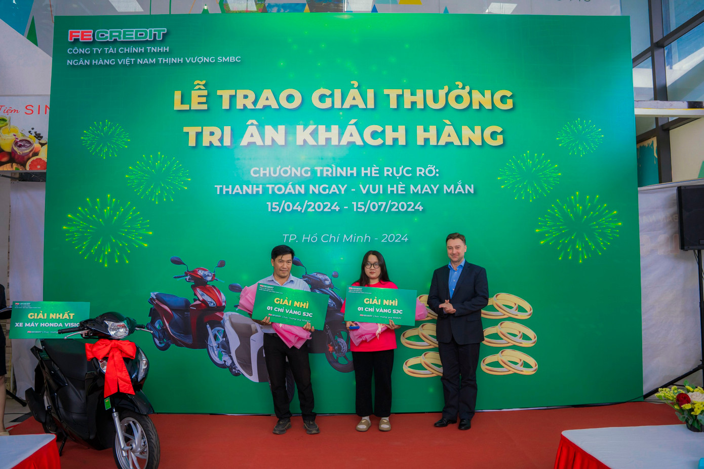 Đại diện FE CREDIT trao hai giải nhì là hai chỉ vàng SJC cho khách hàng may mắn trúng thưởng. Ảnh: FE CREDIT.