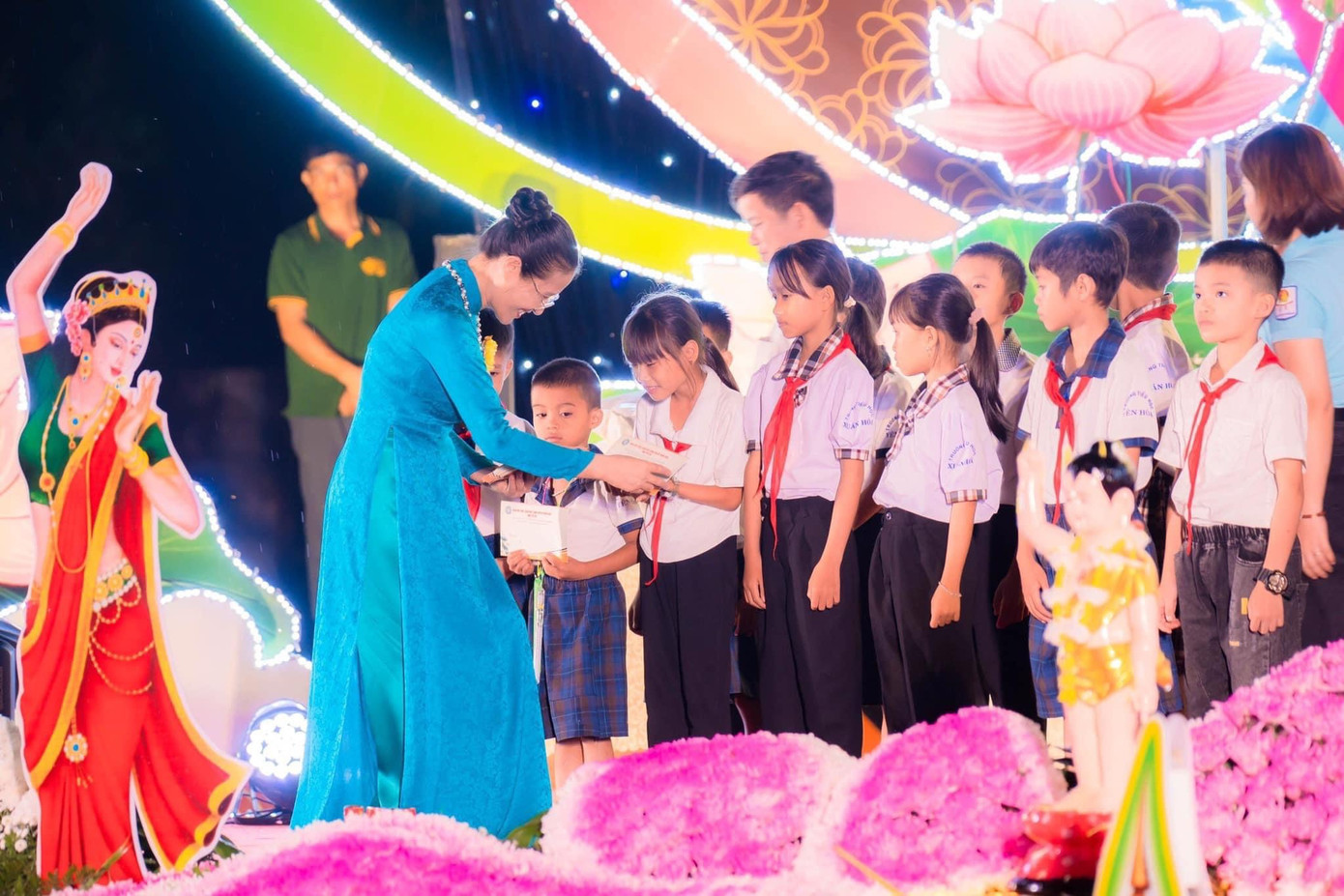 Phật tử Phạm Thị Yến - Phó trưởng ban từ thiện GHPGVN tỉnh Quảng Bình, trưởng ban từ thiện GHPGVN huyện Minh Hoá trao quà cho các em học sinh có hoàn cảnh khó khăn.