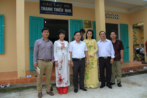 Lãnh đạo, phóng viên báo Tiền Phong chụp ảnh kỷ niệm trước nhà CLB Thanh thiếu nhi xã Minh Thanh, công trình do báo Tiền Phong hỗ trợ xây dựng. Ảnh: Trường Phong