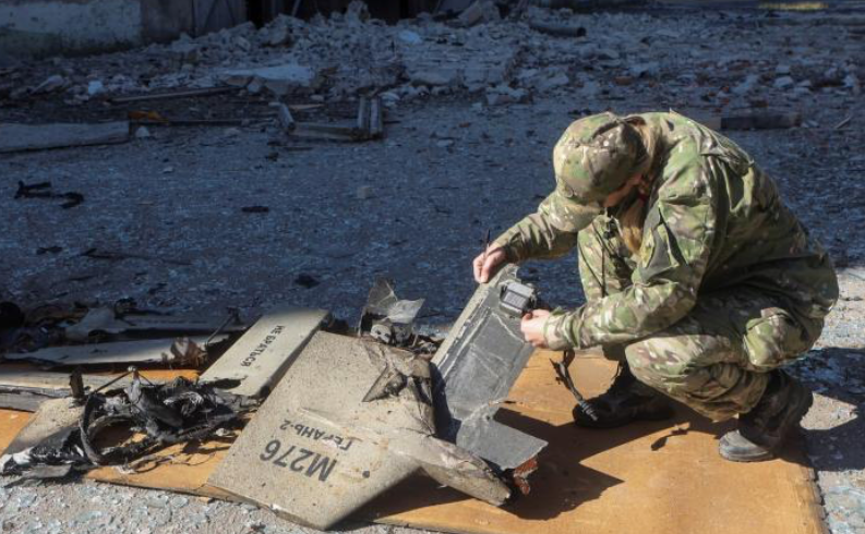 Lính Ukraine kiểm tra các bộ phận được cho là của máy bay không người lái Kamikaze tại hiện trường một vụ tấn công