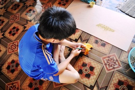 Quang đang cắt những phế liệu để làm tranh.