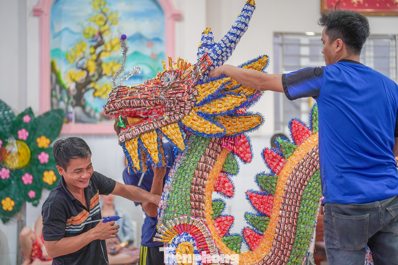 Năm nay, hộ anh Nguyễn Hoài Trung, ngụ KP 3, thị trấn Tầm Vu (huyện Châu Thành) bắt tay làm linh vật rồng bằng bánh kẹo từ mùng 6 Tết. Sau 8 ngày miệt mài với khoảng 5-7 nhân công, chú rồng hoàn thiện được khoảng 90%.