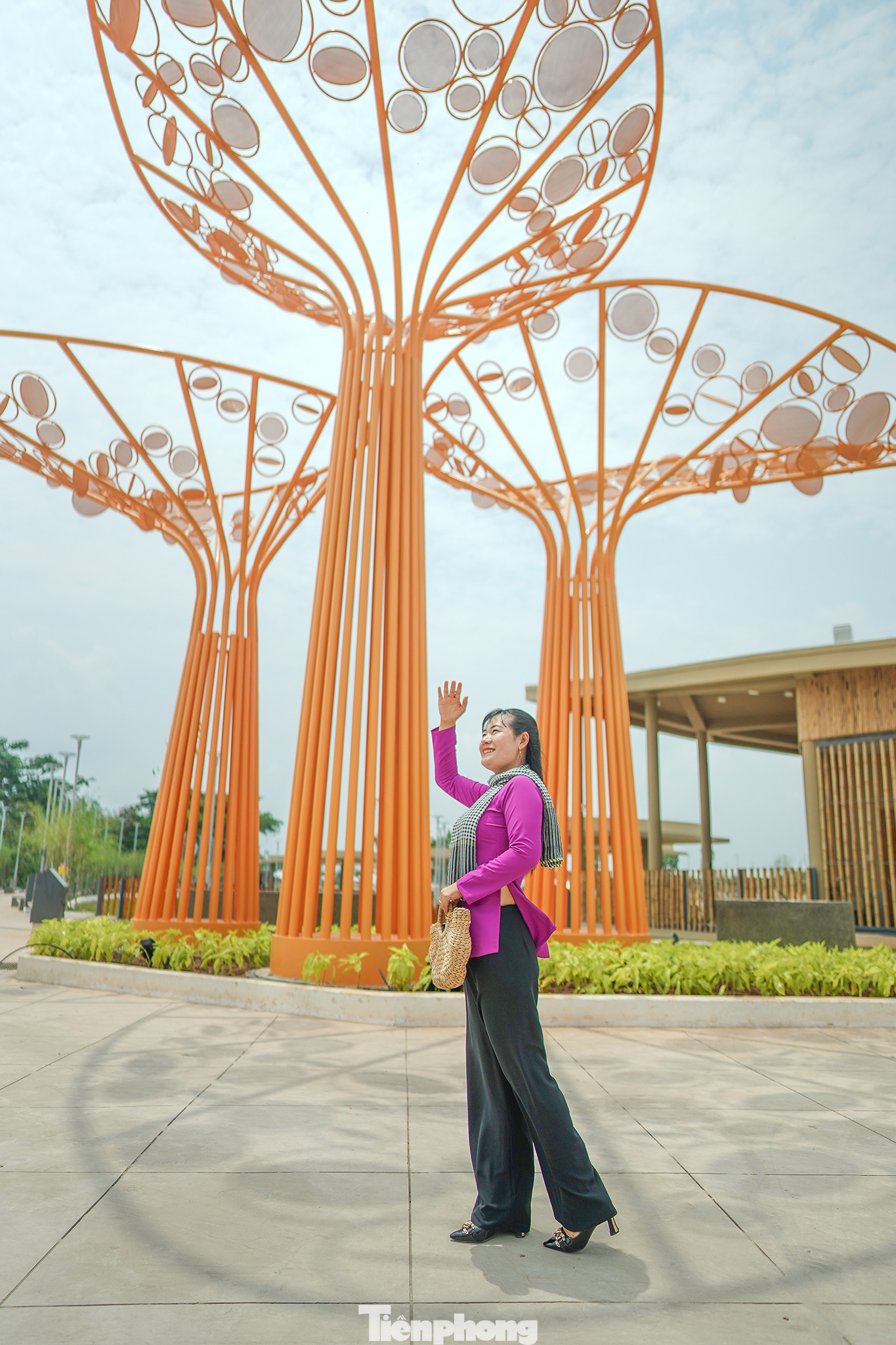 Chị Kim Chi nhà gần khu công viên đang tạo dáng bên tiểu cảnh cây cao trong trang phục áo bà ba. Huyện Hóc Môn nổi tiếng với địa danh "18 thôn vườn trầu" giàu truyền thống cách mạng.