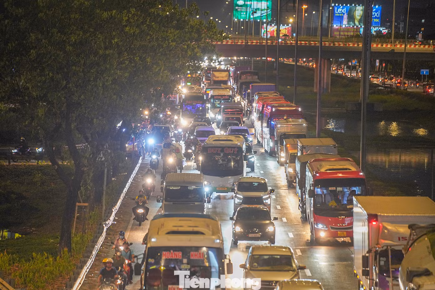 Từ cầu vượt vào đại lộ Võ Văn Kiệt, phương tiện nối nhau kéo dài cho đến ranh giới TPHCM - Long An (đoạn vào huyện Bến Lức). Trong ảnh ngay đoạn đèn tín hiệu, dòng phương tiện nối nhau thành hàng dài hướng lên cầu Bình Điền.