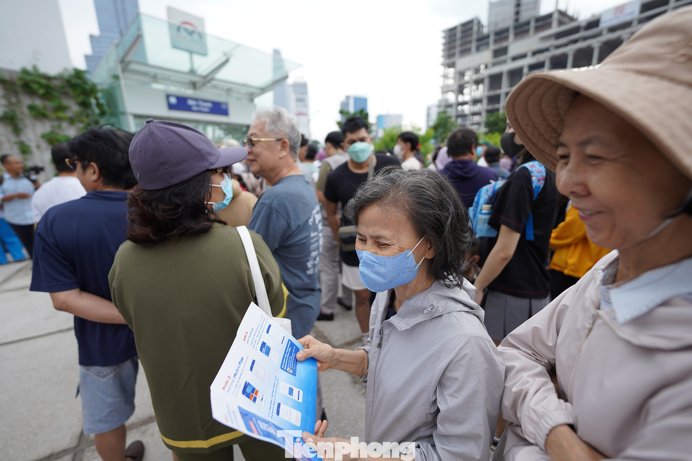 Một hành khách tìm hiểu cách mua vé tàu metro qua ứng dụng điện thoại.