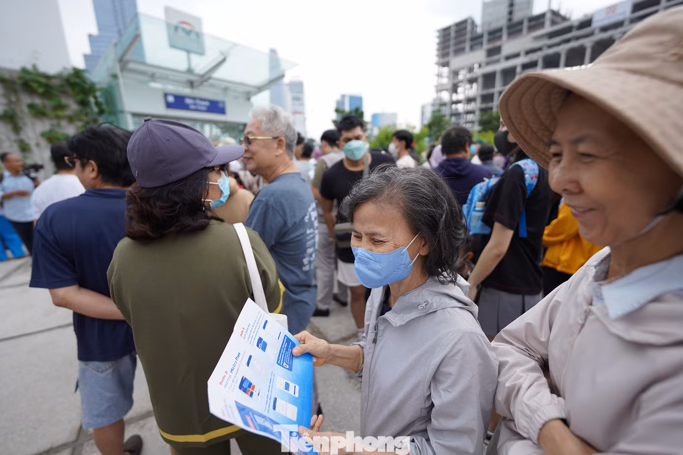 Một hành khách tìm hiểu cách mua vé tàu metro qua ứng dụng điện thoại.