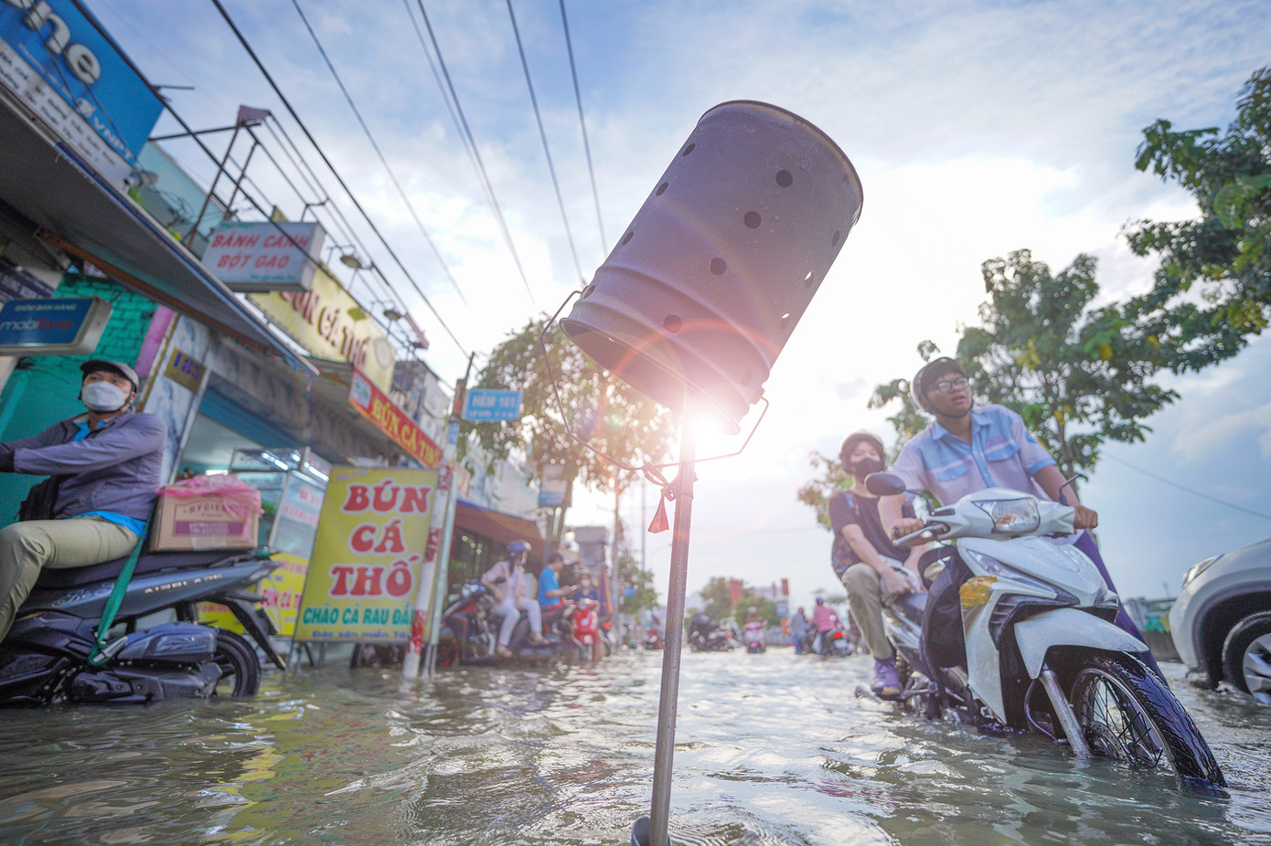 Người dân trên đường Trần Xuân Soạn đã quen với cảnh triều cường. Tại vị trí các hố ga, người dân cắm cọc cảnh báo cho người đi đường.
