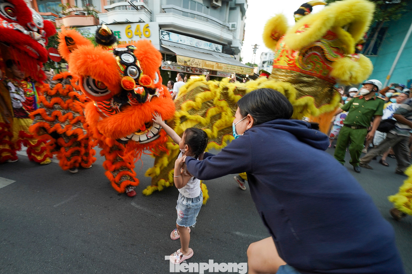Chú lân này dừng biểu diễn vài giây để cho cô bé sờ lấy may.