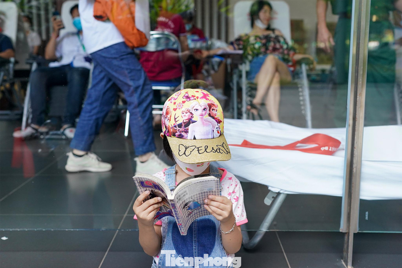 Một em nhỏ tìm được góc riêng ngồi &quot;ngấu nghiến&quot; truyện tranh chờ ba mẹ hiến máu.