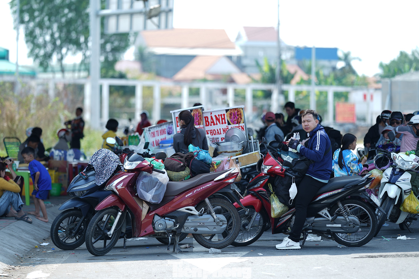 Người dân dừng nghỉ ngay bên dưới nút giao cao tốc Bến Lức - Long Thành - Quốc lộ 1A sau hành trình dài dưới thời tiết nắng nóng.