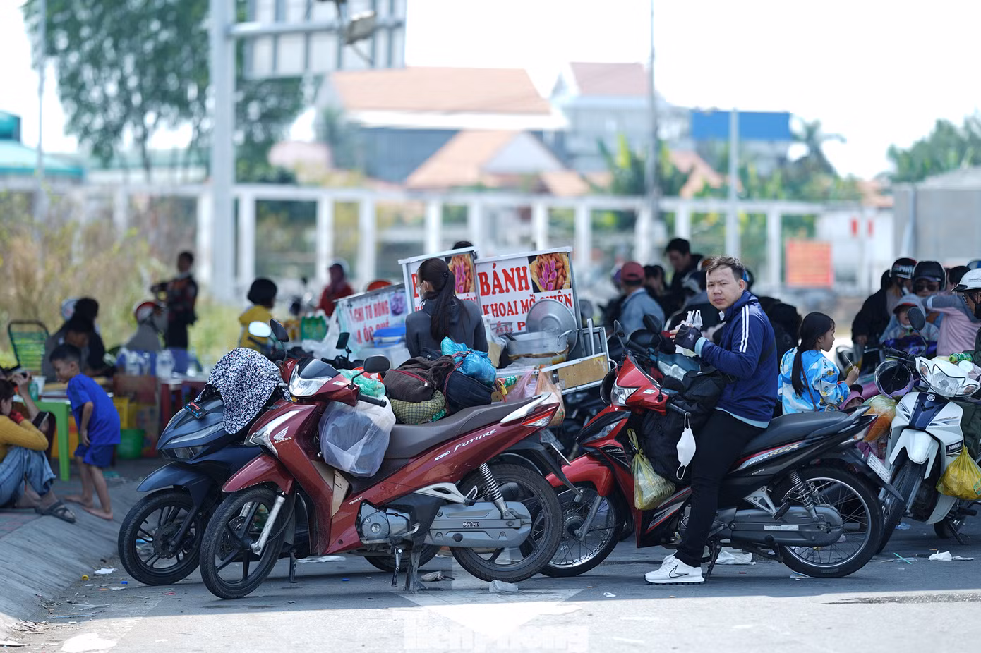 Người dân dừng nghỉ ngay bên dưới nút giao cao tốc Bến Lức - Long Thành - Quốc lộ 1A sau hành trình dài dưới thời tiết nắng nóng.