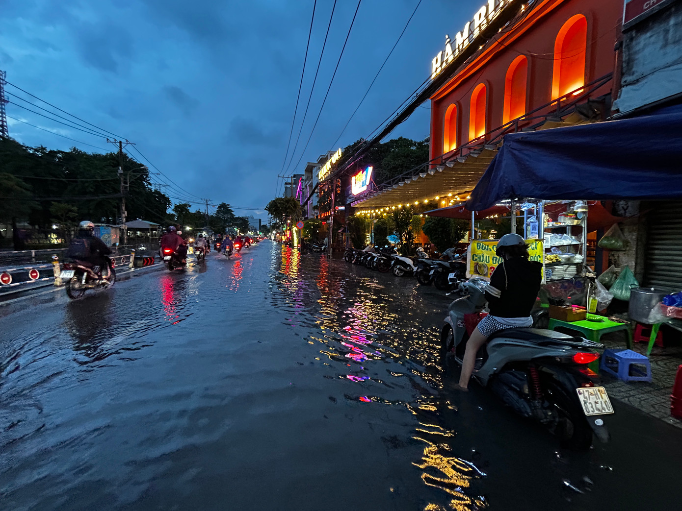 Mưa to, đường ngập làm người tham gia giao thông gặp nhiều khó khăn.