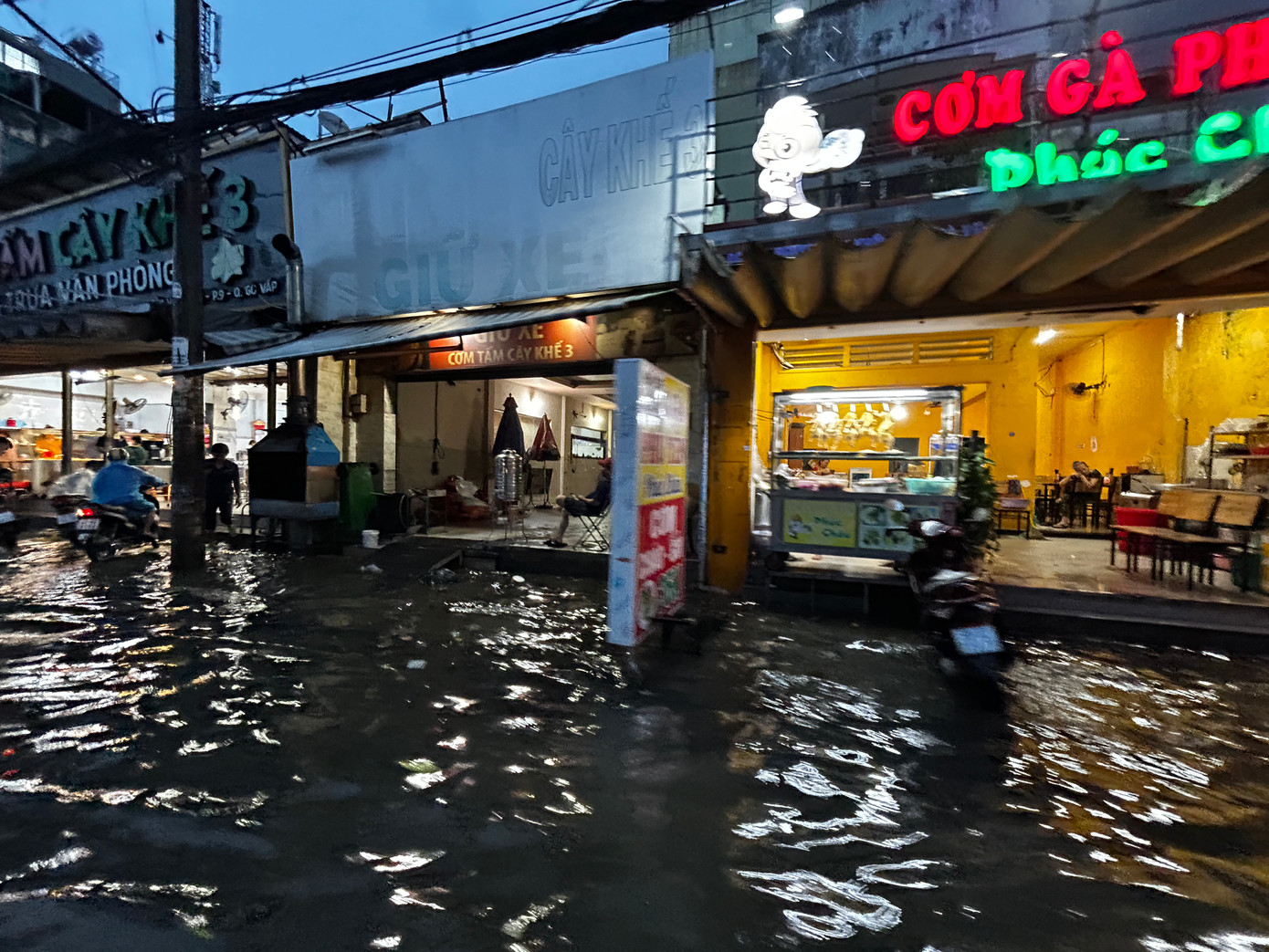 Hàng quán kéo hết kệ tủ lên trên nền nhà vì vỉa hè ngập sâu.