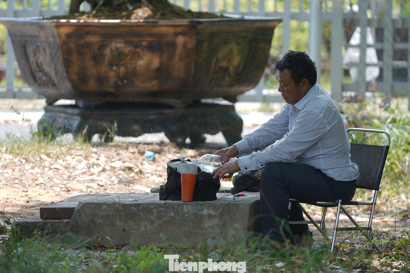 Một người đàn ông đang đổ nước vào phích đá lạnh tại khuôn viên cây xanh gần KCN Vĩnh Lộc. Một người đàn ông đang đổ nước vào phích đá lạnh tại khuôn viên cây xanh gần KCN Vĩnh Lộc.