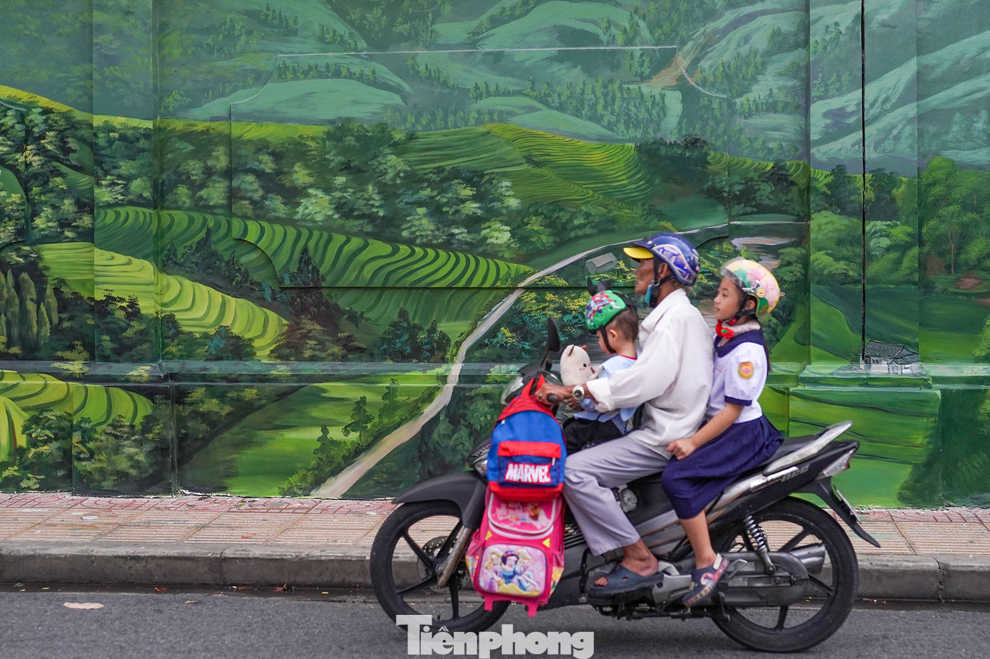 Giờ tan trường, một phụ huynh đón cháu chạy ngang bức tranh tả ruộng bậc thang Tây Bắc đẹp như tả thực với nhiều mảng sáng tối hài hòa.