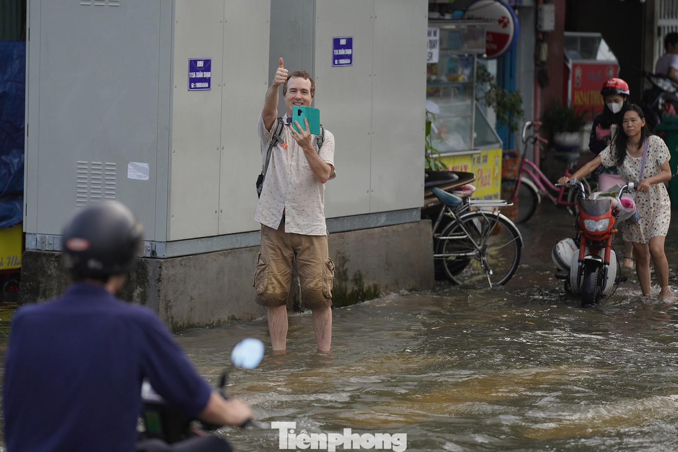 Một du khách tranh thủ ghi lại khoảnh khắc lội nước trên phố.