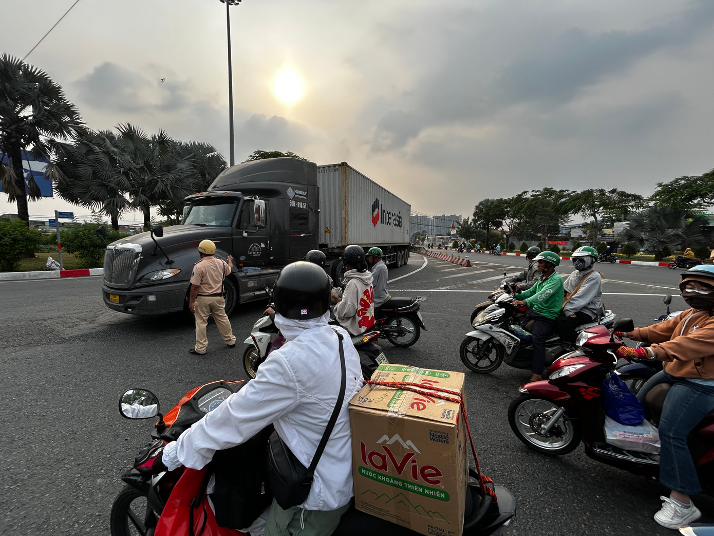 Dòng phương tiện di chuyển dưới sự điều tiết của CSGT tại vòng xoay cầu vượt Nguyễn Văn Linh (quận Bình Tân)