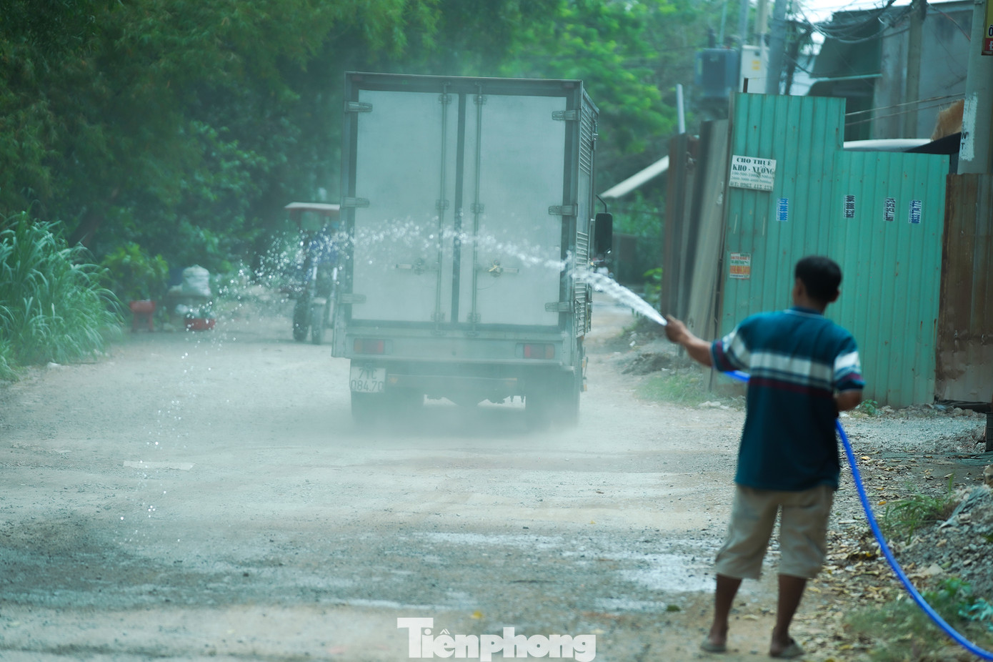 Ở những đoạn đường chưa thi công, người dân phải tự thích nghi, cứ bụi mù thì kéo ống nước ra xịt.