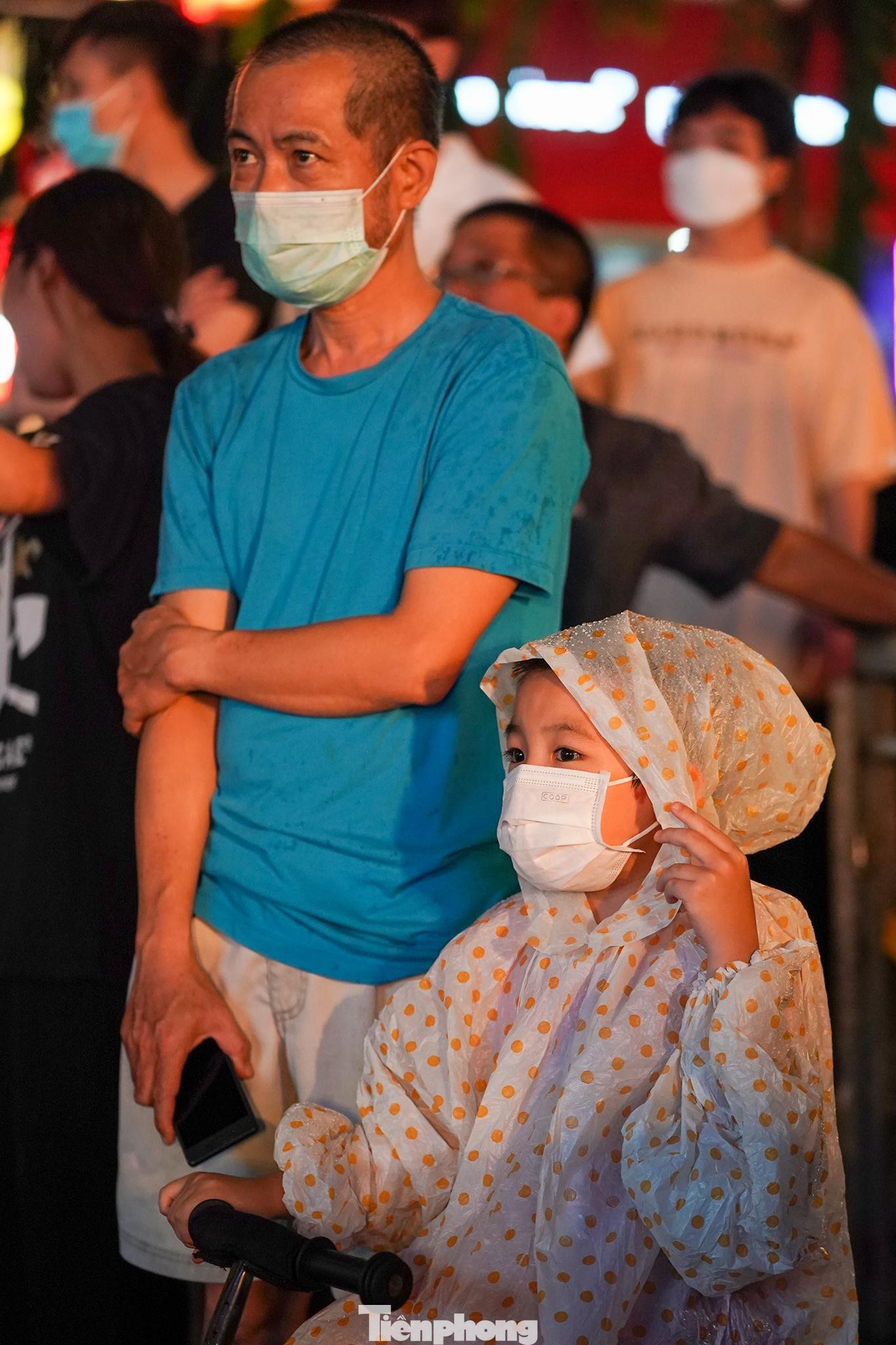 Một em nhỏ theo dõi trận đấu trong chiếc áo mưa. Một em nhỏ theo dõi trận đấu trong chiếc áo mưa.